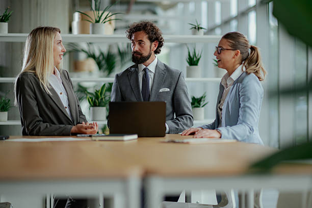 Business team discussing strategy in modern office with laptop