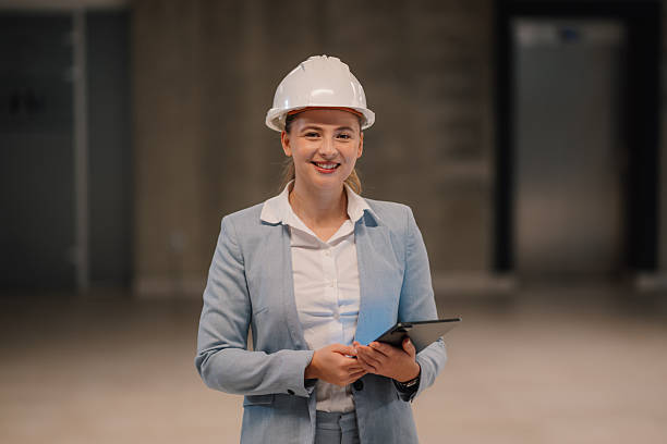istock Female engineer smiling and holding tablet in building under construction 2223735148