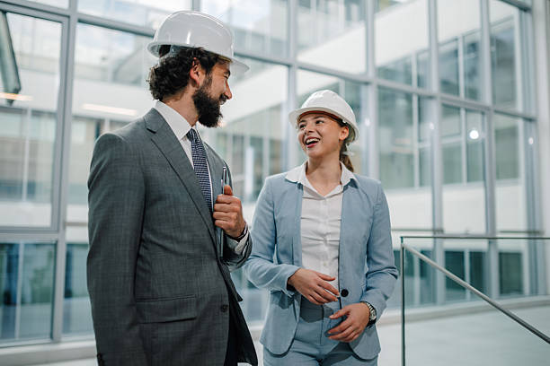 istock Smiling architects walking and talking in modern office building 2223735193