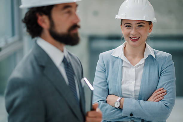 istock Smiling architects wearing hardhats at construction site 2223735211
