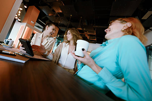 istock Three businesswomen engaged in a collaborative discussion in a modern office space while sharing ideas over coffee and digital devices 2223737384