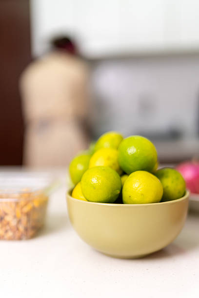 Bowl filled with fresh limes, perfect for preparing authentic peruvian ceviche in a cozy home kitchen, showcasing vibrant ingredients