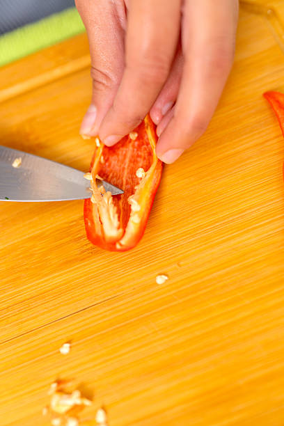istock Chef removing seeds from a red chili pepper on a wooden cutting board 2223744445