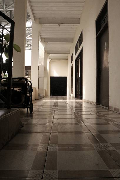 istock A quiet corridor with tiled flooring is lit by soft natural light. 2223749247