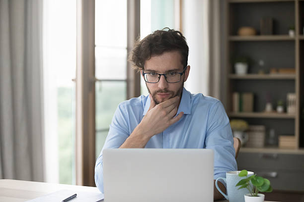 istock Serious thoughtful millennial man staring at laptop, read received message 2223754485