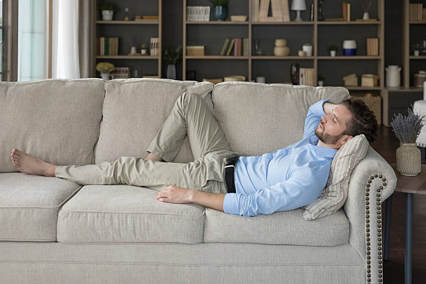istock Side view man enjoy daytime nap on comfy sofa 2223754508