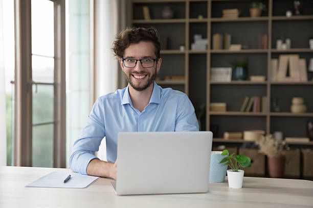istock Office employee in glasses sitting at desk looking at camera 2223754552