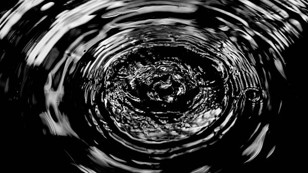 istock Water ripples or water drops splashing on black background. 2223755268