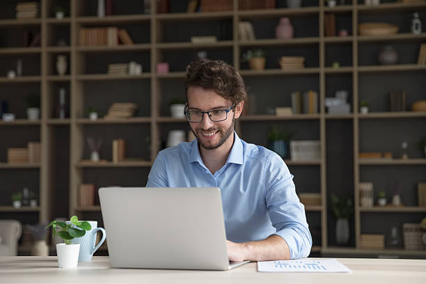 istock Smiling businessman, freelance sit at desk working on laptop 2223756227