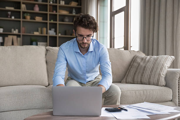 istock Serious man sit on sofa do accounting work from home 2223756731