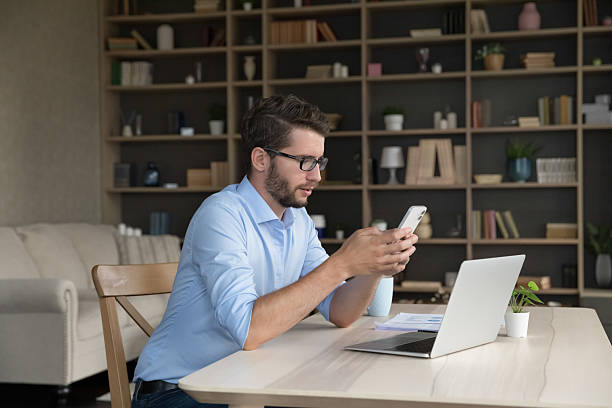 istock Serious businessman sit at workplace desk with smartphone 2223757161