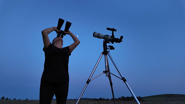 istock Amateur astronomer using telescope and binoculars for watching stars, Moon, planets and other celestial objects from a field in nature. 2223758872
