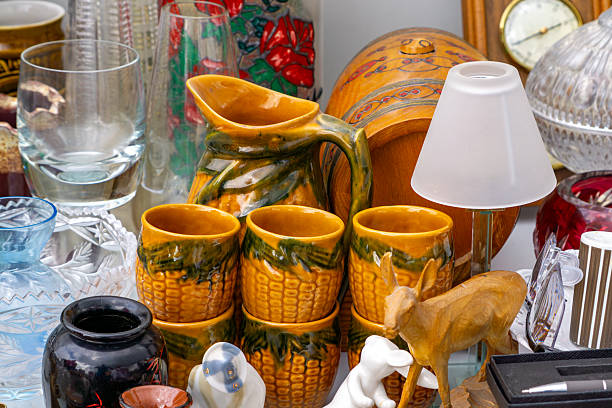 istock Corn cob mugs and jug surrounded by glassware and trinkets on a flea market stall. 2223759517