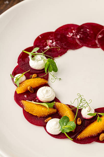 istock Beet carpaccio with orange slices, fresh greens and cream dots 2223760072