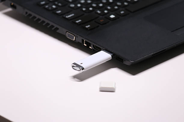 istock White USB Flash Drive Plugged into a Black Laptop Port, Illustrating Data Transfer, Storage, and Digital Connectivity. 2223760282