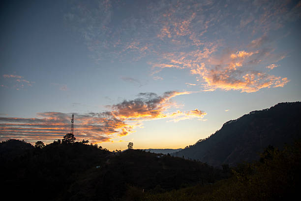 istock Cell Tower Amidst Glowing Hillside Sunset in Uttarakhand Village Landscape 2223760464