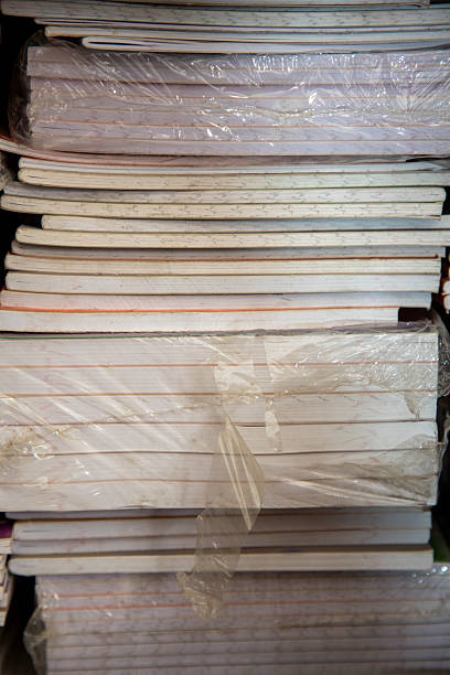 Stacked Piles of Notebooks and Papers Arranged on a Shelf