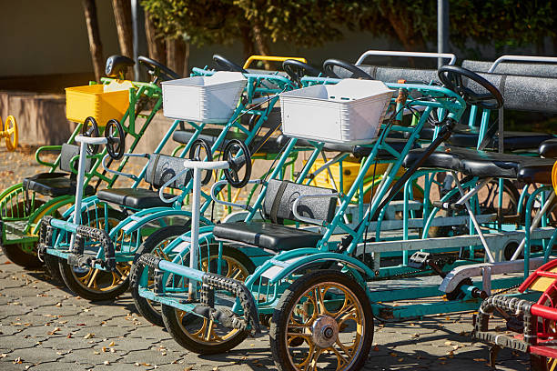 Rental mechanical quadricycle in the park. Four person tandem bicycle for rent