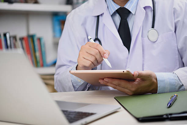 istock Physician hands holding digital tablet, close-up, working with laptop, medical data, modern hospital, professional healthcare, secure messaging, health information, electronic records. 2223762063