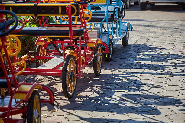 Rental mechanical quadricycle in the park. Four person tandem bicycle for rent