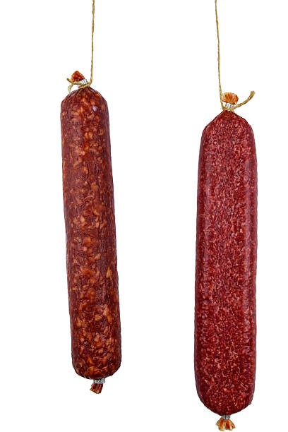 istock Two hanging raw smoked sausage isolated on white background 2223762622
