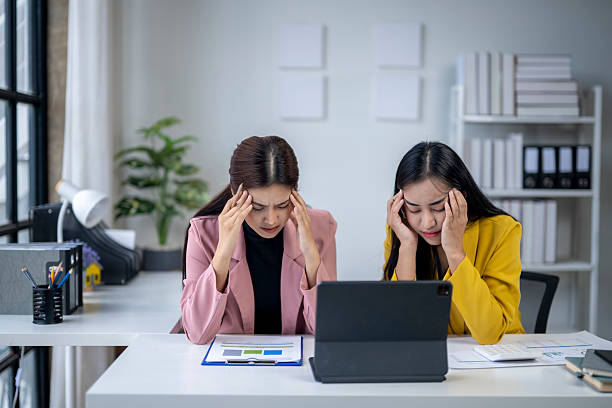 istock Two businesswomen suffering from headache while working in office 2223765327