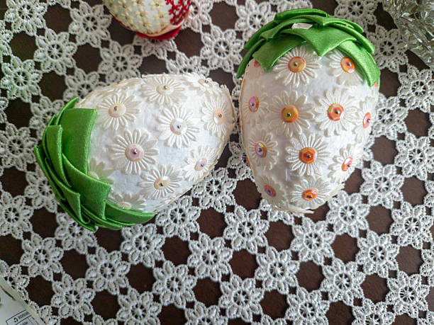 Traditional Easter eggs decorated with floral patterns and vibrant colors displayed on a lace tablecloth, showcasing artisanal craftsmanship and seasonal celebration.