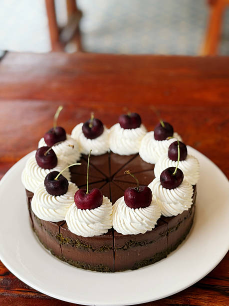 istock Chocolate cake with whipped cream and cherries on wooden table. 2223766585