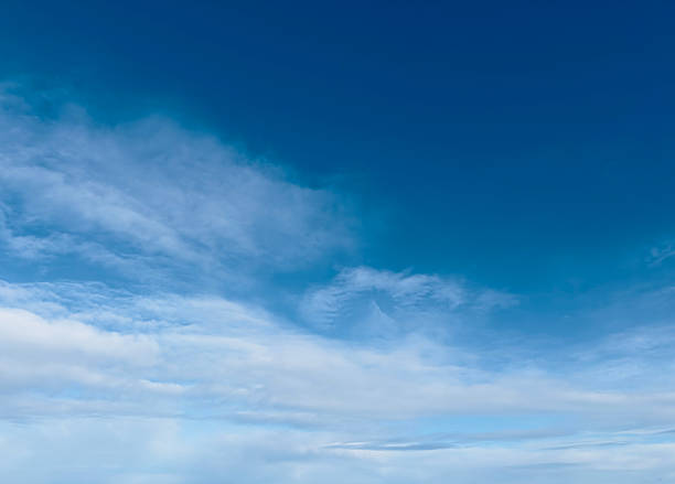 The beautiful blue sky is filled with soft, white, fluffy clouds on a bright and sunny day.