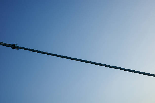 istock A rope tight between pole on a long-tail boat, has a light blue sky as the background 2223777067