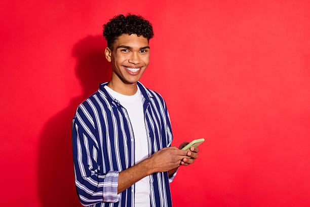 Portrait of attractive cheerful brunet guy using device app 5g chatting copy space isolated over bright red color background