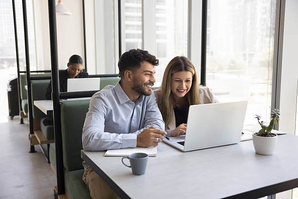 istock Happy pair of businesspeople work together in coworking using notebook 2223781113