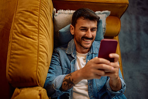 istock Above view of happy man using cell phone on the sofa. 2223786274