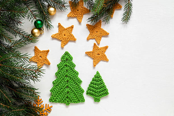 istock Festive Christmas composition on a white background. Handmade crochet green Christmas tree and yellow stars. Copy space. 2223786407