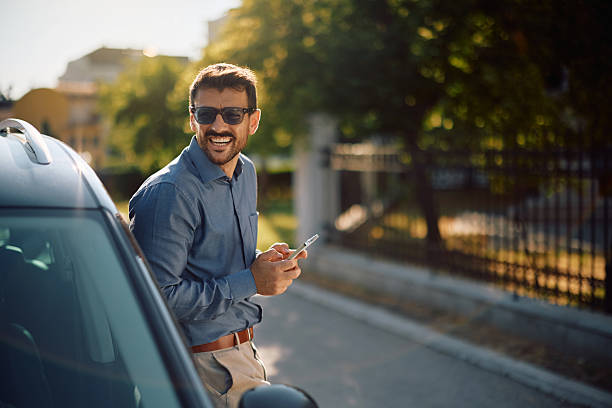 istock Happy businessman using cell phone while leaning on his car. 2223787719