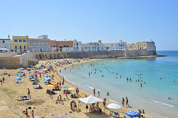 Gallipoli, Apulia, Italy - September 06, 2024 - Families relaxing on the sandy beach in the heat of the summer in Gallipoli.
