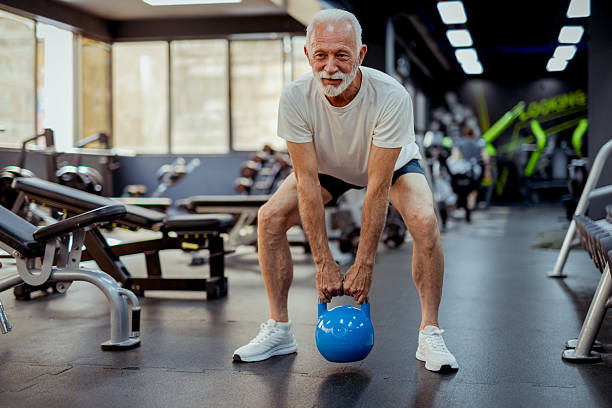 istock Sporty Senior Male Doing Kettlebell Workout at Gym 2223798217