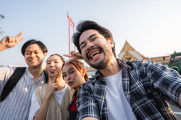 istock Group of friends taking pictures and filming themselves with digital camera while exploring the city of Bangkok 2223799564
