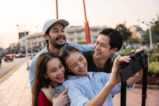 istock Group of friends taking pictures and filming themselves with digital camera while exploring the city of Bangkok 2223799583