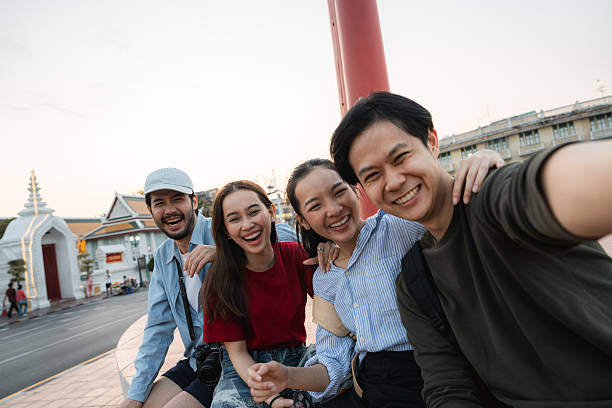 istock Group of friends taking pictures and filming themselves with digital camera while exploring the city of Bangkok 2223799610