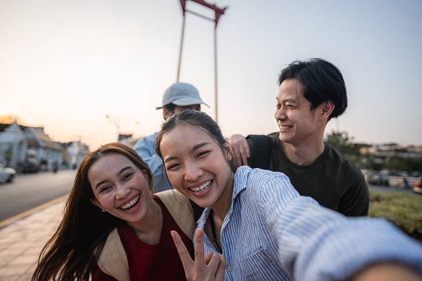 istock Group of friends taking pictures and filming themselves with digital camera while exploring the city of Bangkok 2223799672