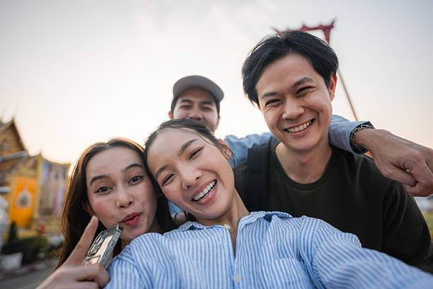 istock Group of friends taking pictures and filming themselves with digital camera while exploring the city of Bangkok 2223799697