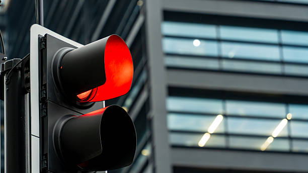 istock Red traffic light in front of modern office building facade 2223800825