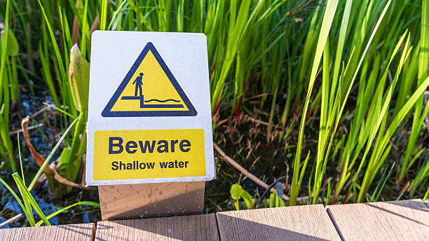 istock Caution sign warns of shallow water near decking 2223801040