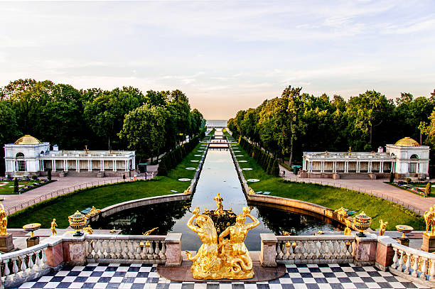 September 17, 2024, St. Petersburg, Russia. Tourists wander through Peterhofs gardens, enjoying vibrant flowers and fountains set amid green trees in autumn.