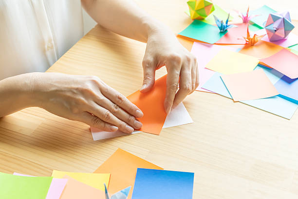 istock Origami. Woman's hands folding origami. 2223801249