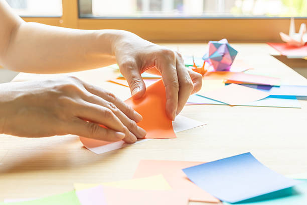 istock Origami. Woman's hands folding origami. 2223801261