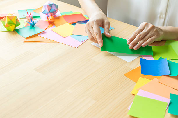 istock Origami. Woman's hands folding origami. 2223801263