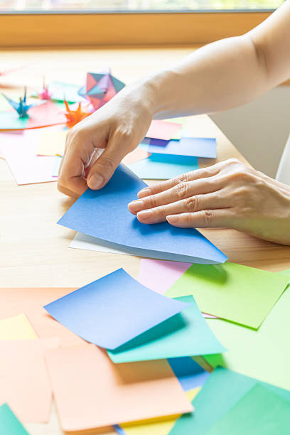 istock Origami. Woman's hands folding origami. 2223801272