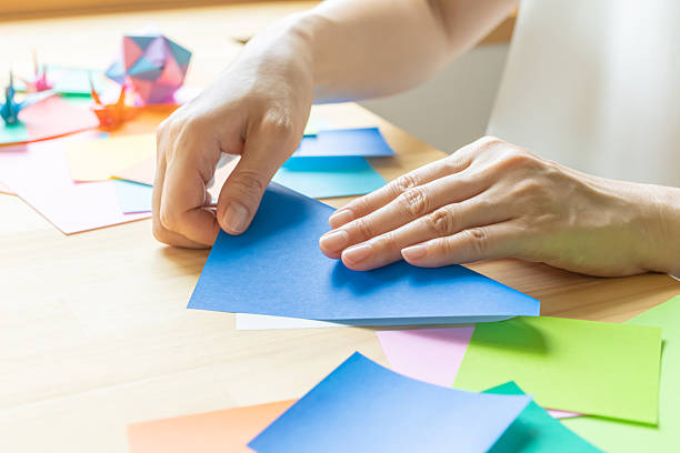 istock Origami. Woman's hands folding origami. 2223801282